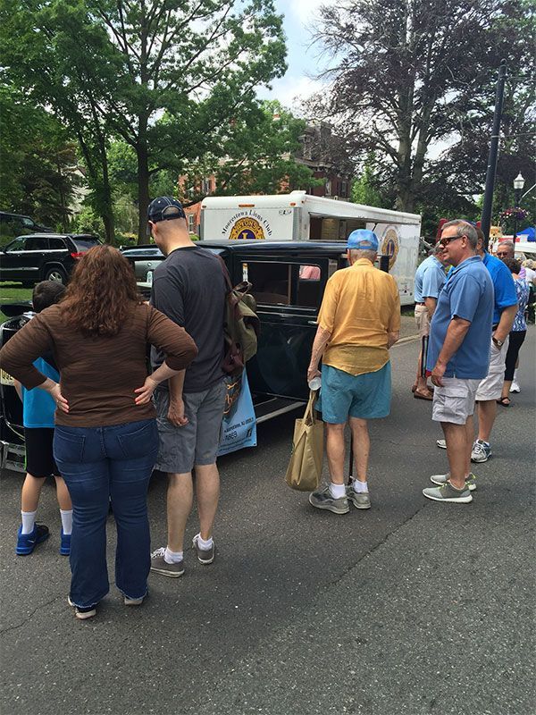 A group of people are standing in front of a car. | InTown Auto Care