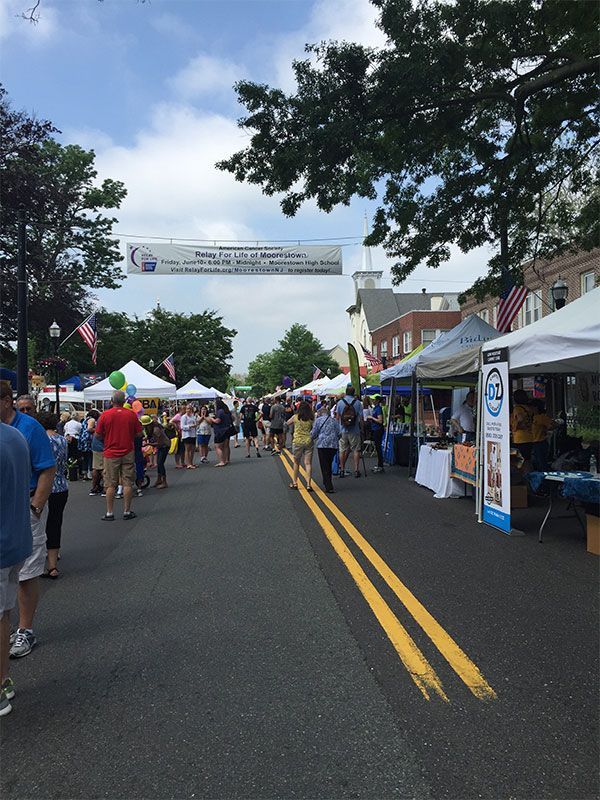 A crowd of people walking down a street with a sign that says ' a ' on it | InTown Auto Care