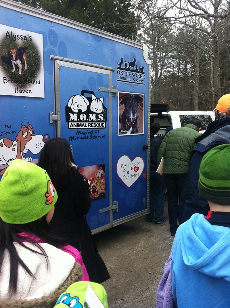 A group of people are standing in front of a blue trailer. | InTown Auto Care