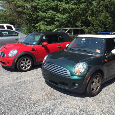 A red mini cooper is parked next to a green mini cooper