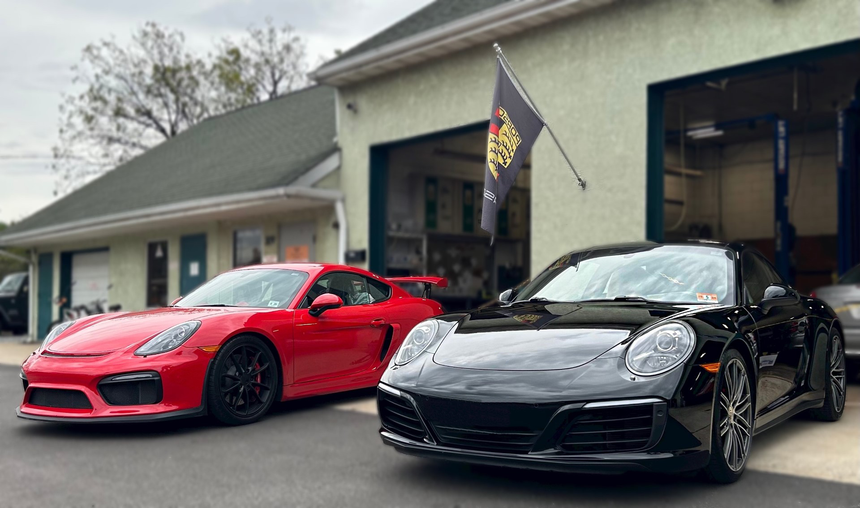 Two sports cars are parked in front of a garage. | InTown Auto Care