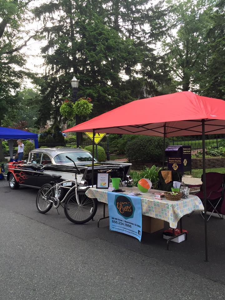 A car is parked next to a table under an umbrella. | InTown Auto Care