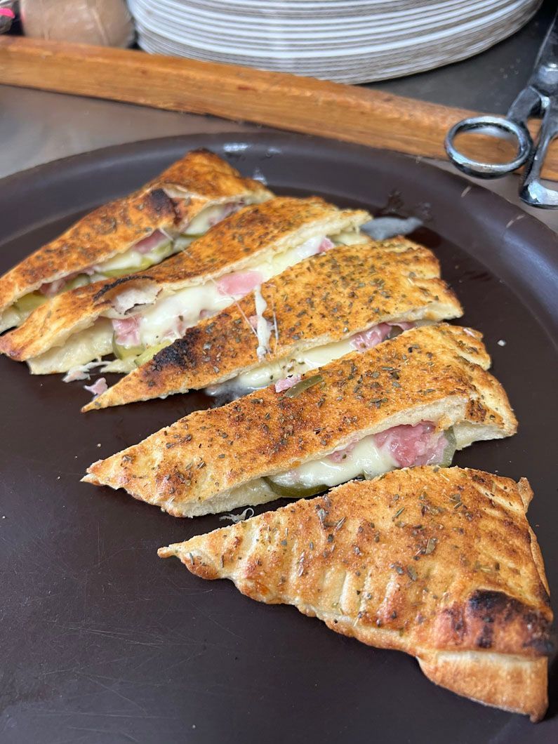 A close up of a pizza on a plate on a table.