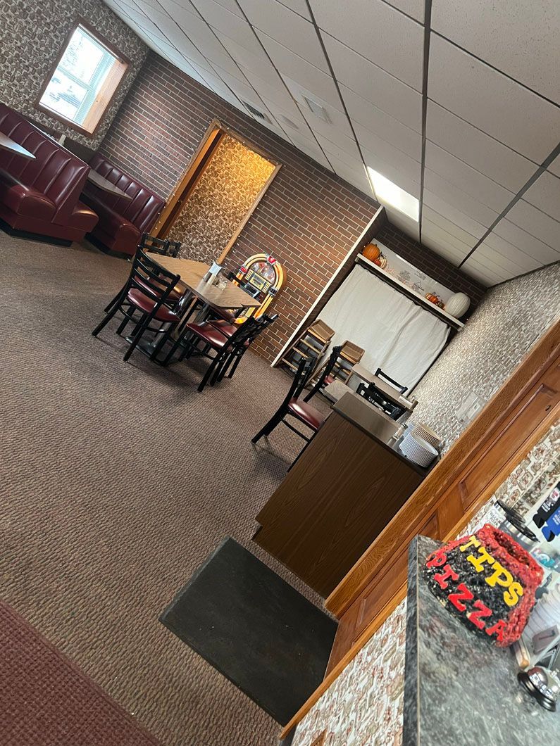 A restaurant with tables and chairs in a large room.