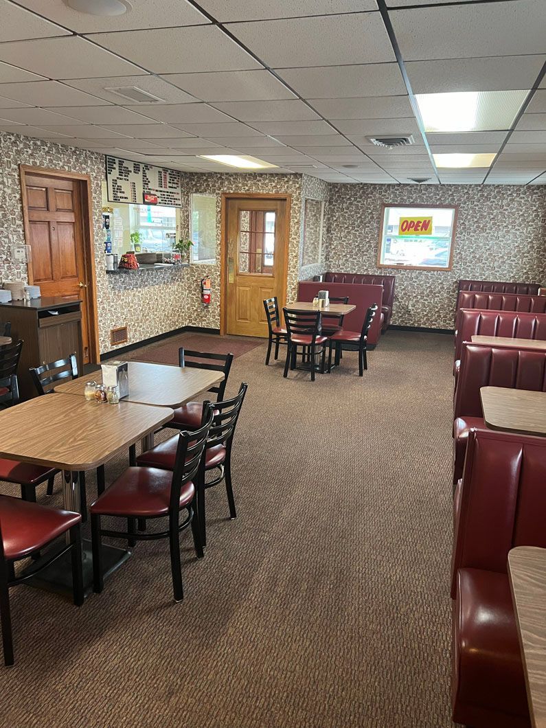 A large dining room with tables and chairs in a restaurant.