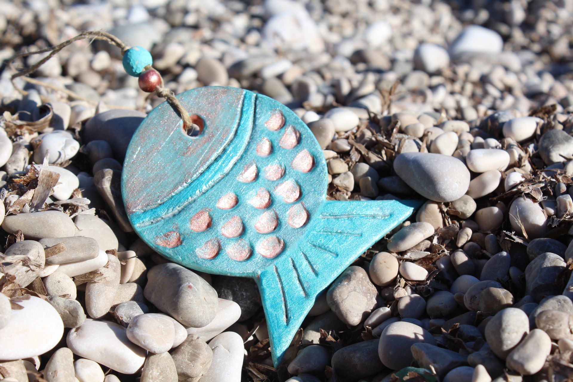 A blue fish is sitting on top of a pile of rocks.