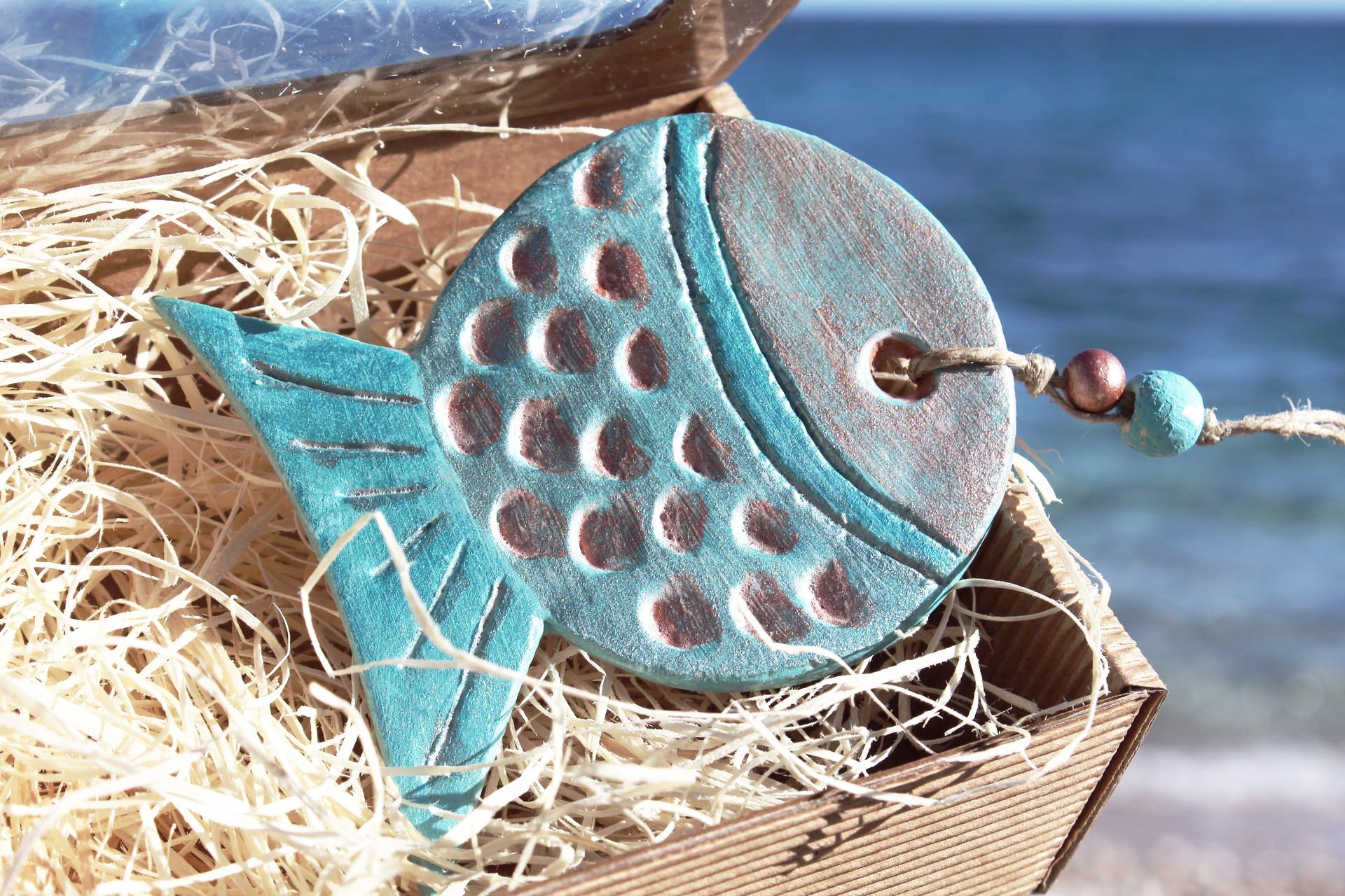 A blue fish is sitting in a box on the beach