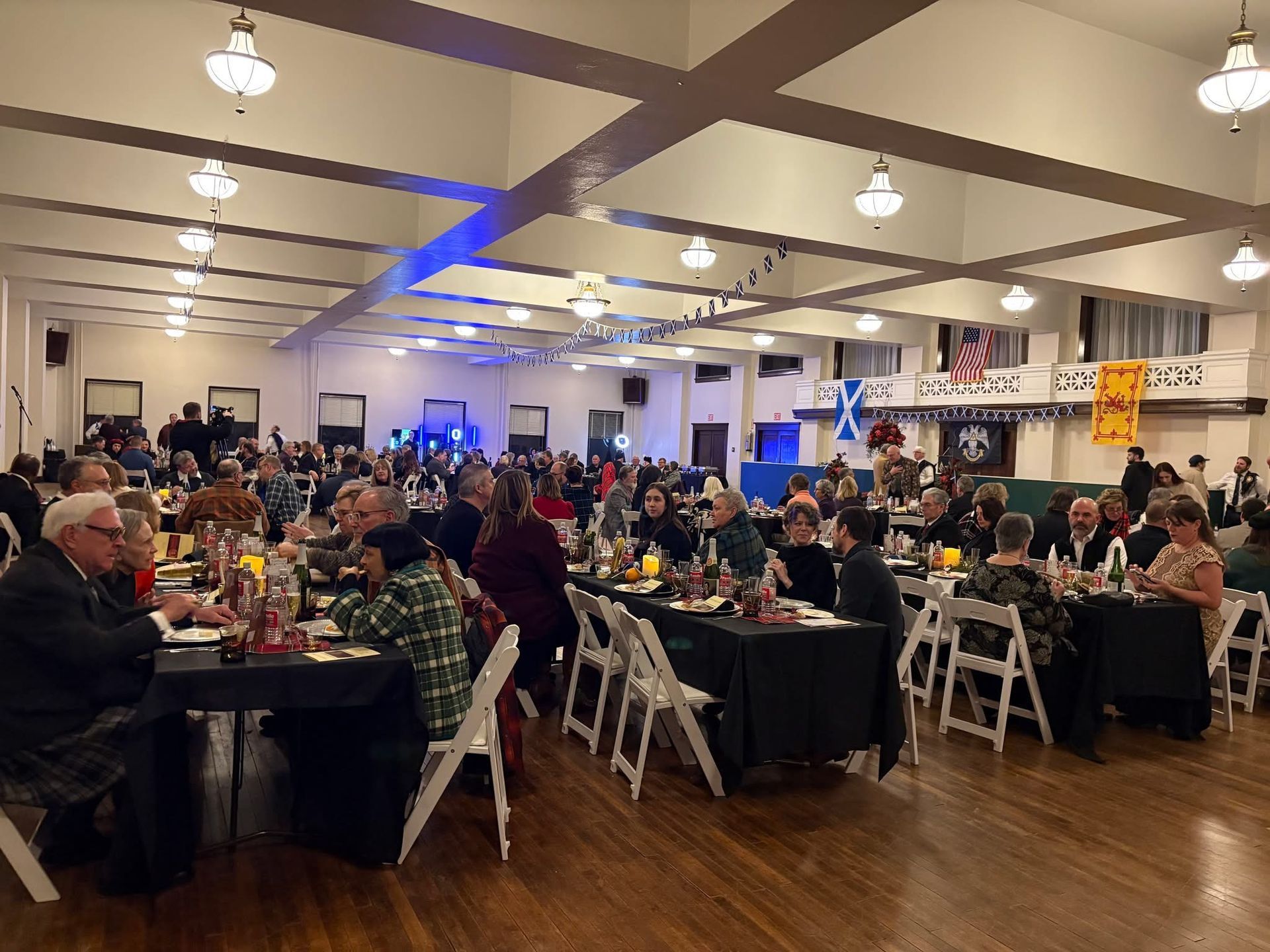 A large group of people are sitting at tables in a large Ballroom.