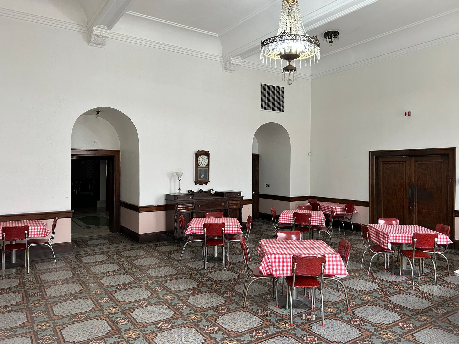 A large Library with a table, chairs, candles, and a rug.