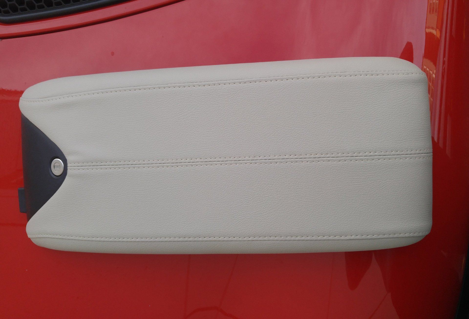 A red car with a white arm rest on it