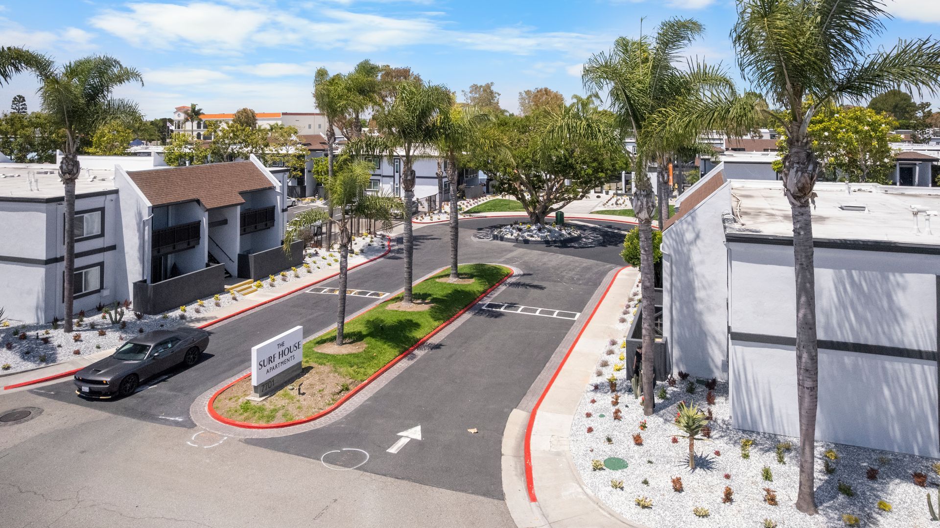 An aerial view of a residential area with a car parked on the side of the road.
