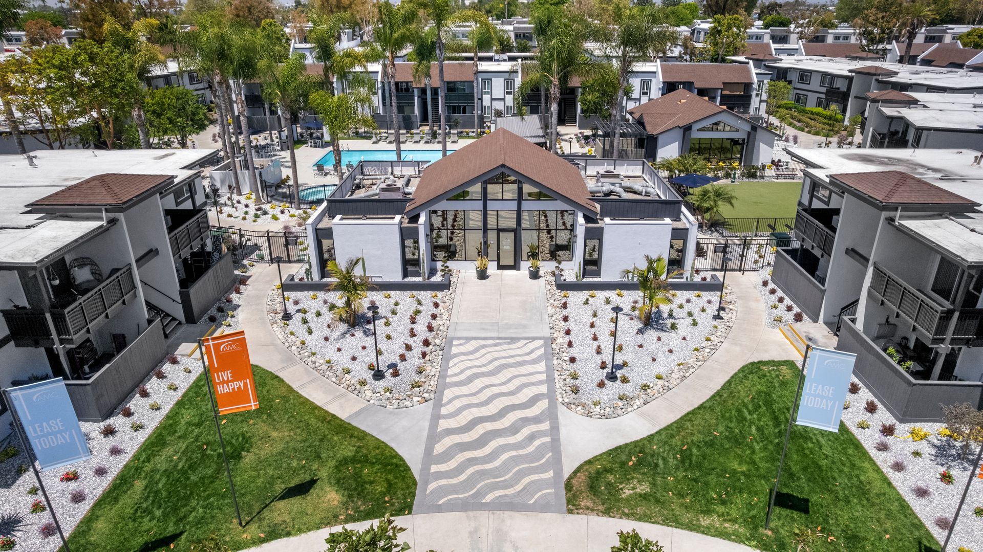 An aerial view of a large apartment complex with a swimming pool in the middle.