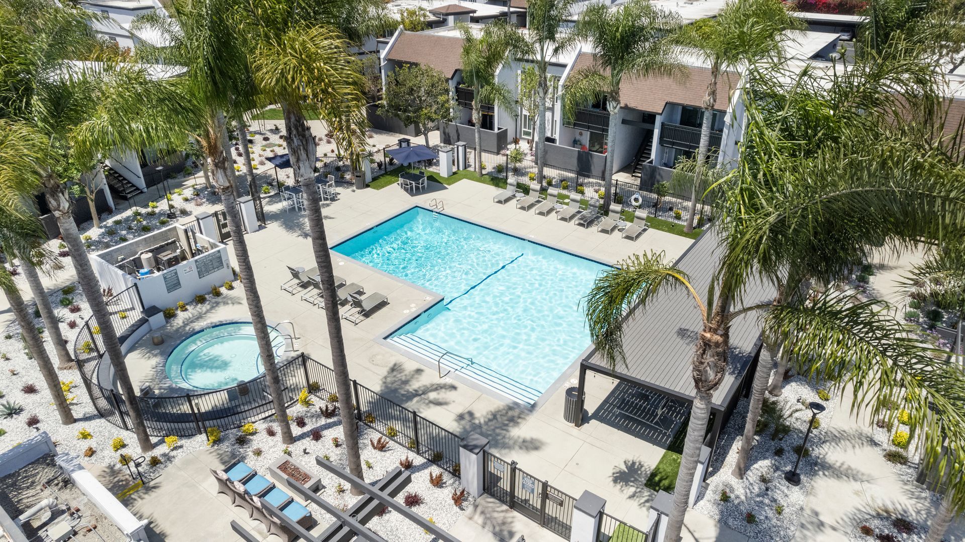 An aerial view of a large swimming pool surrounded by palm trees.