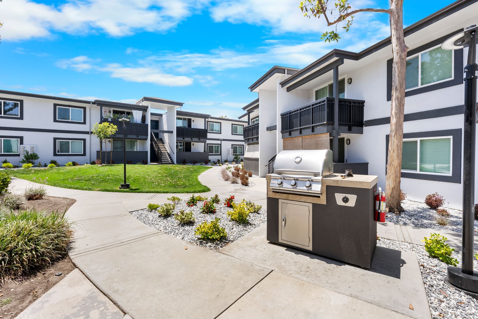 A grill is sitting on the sidewalk in front of a building.