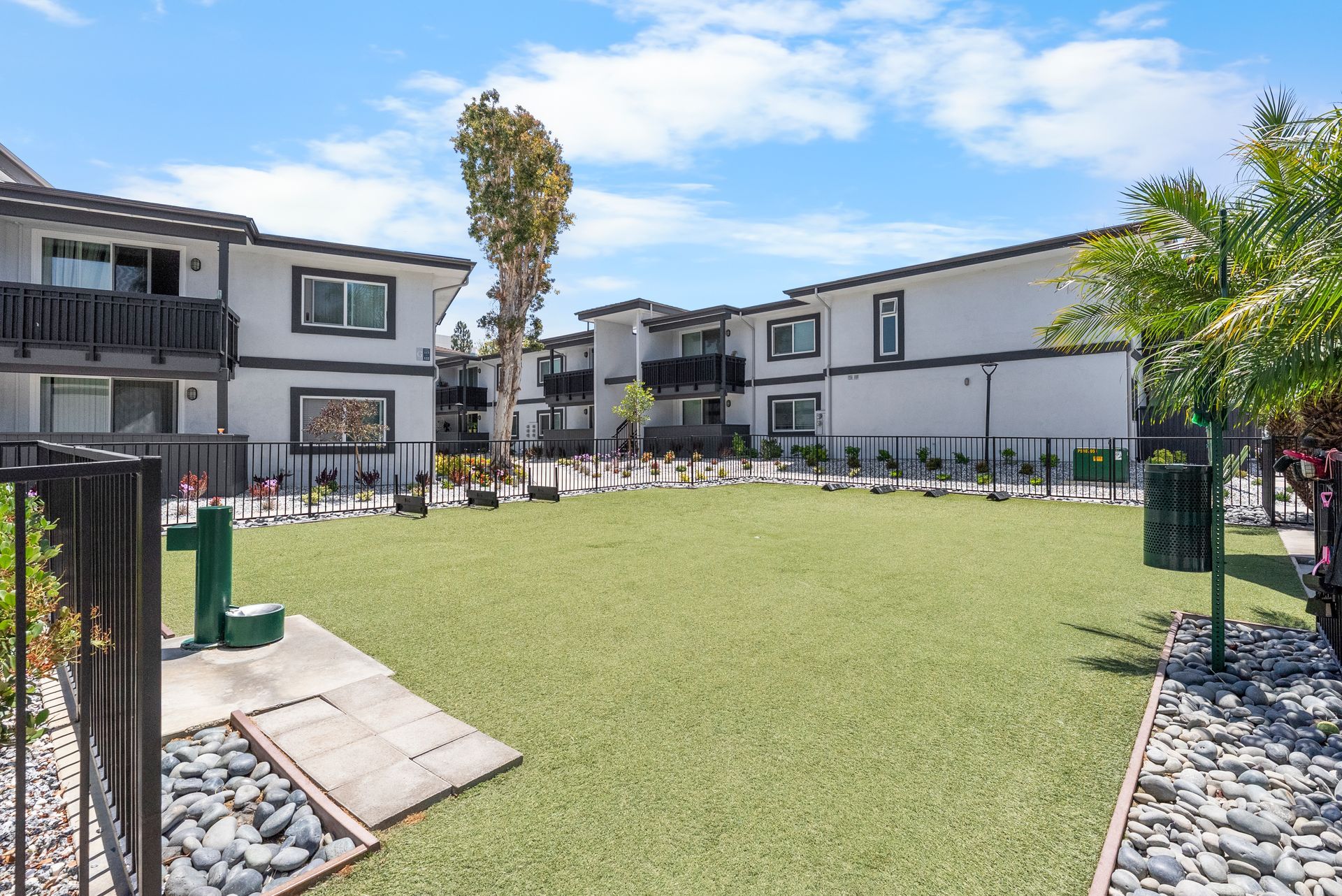 A large lawn dog park in front of a building.