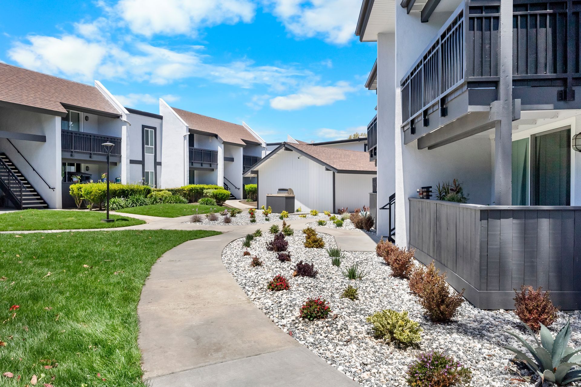 A row of apartment buildings with a walkway between them.