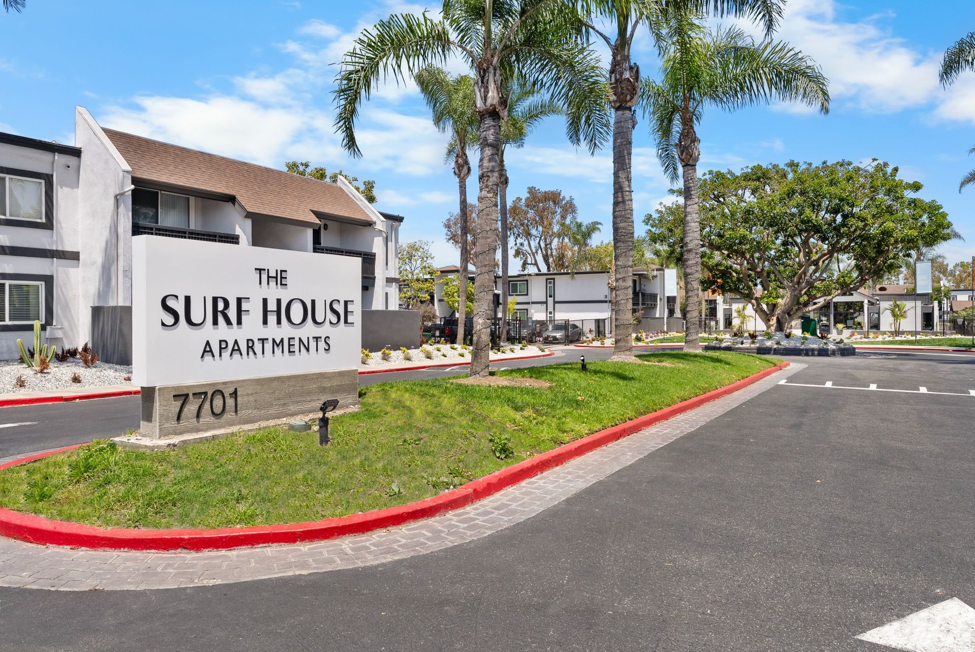 A sign for the surf house apartments is in front of a building.