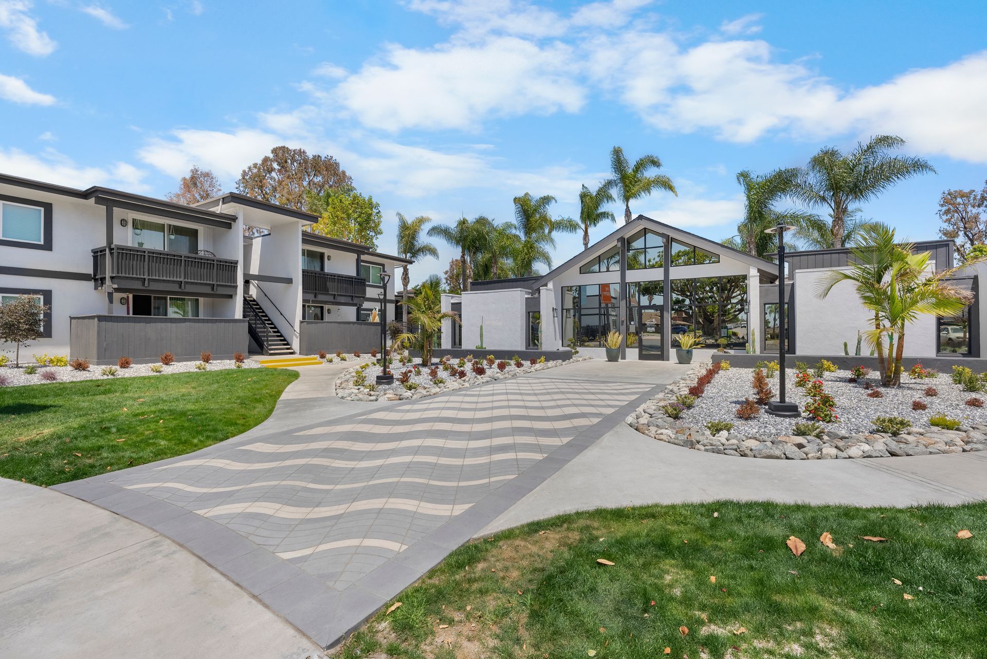 A row of apartment buildings with palm trees in front of them.