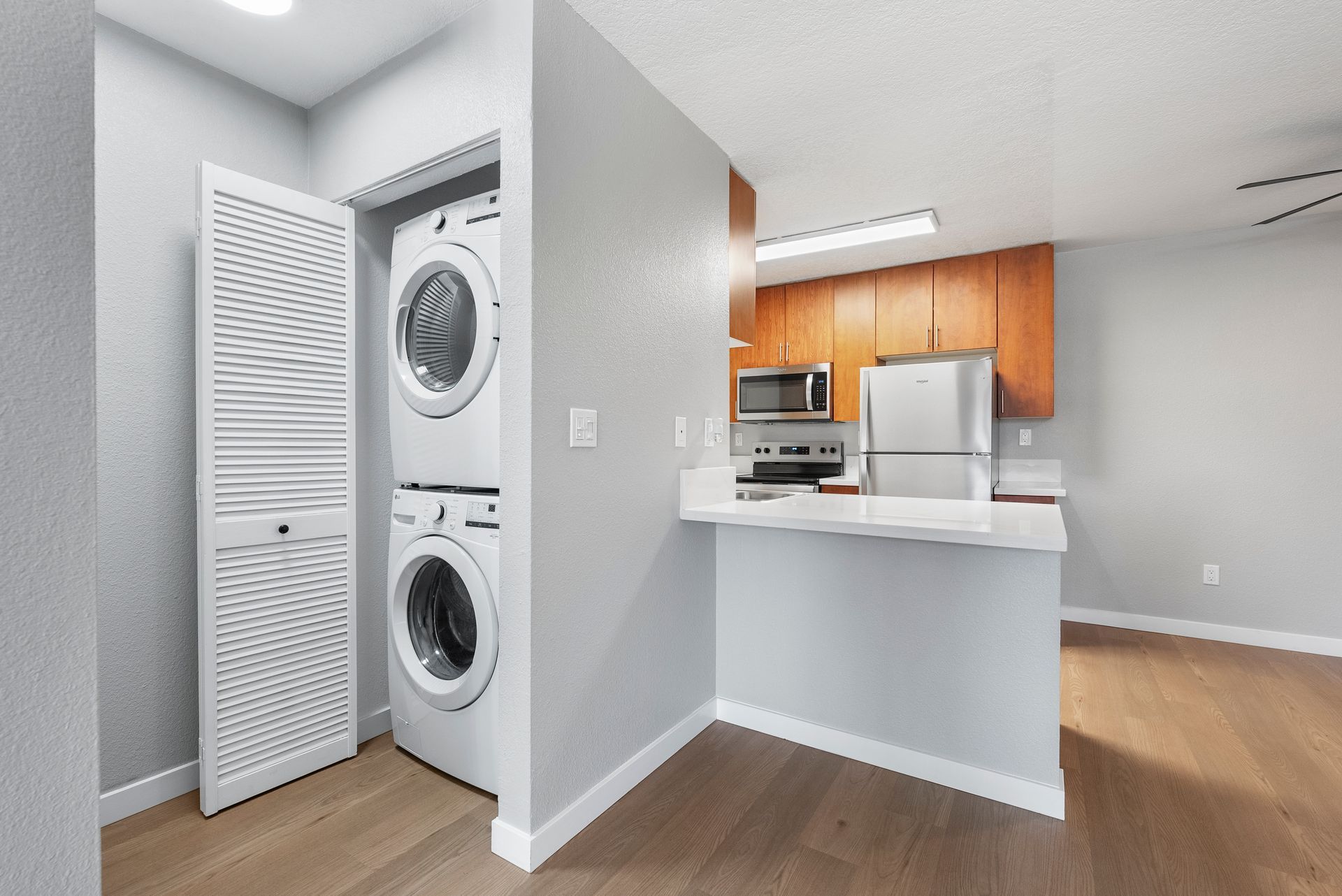 A washer and dryer are stacked on top of each other in a kitchen.