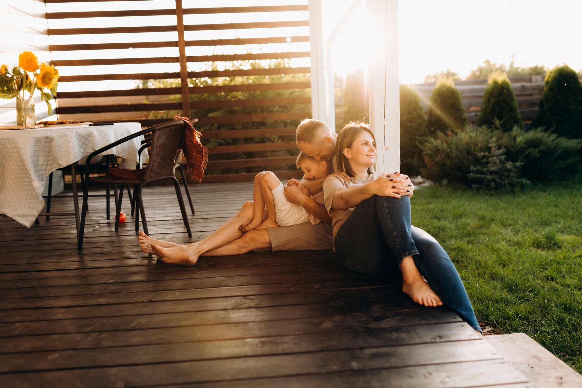 A white mobile home with black shutters is sitting on top of a lush green lawn.