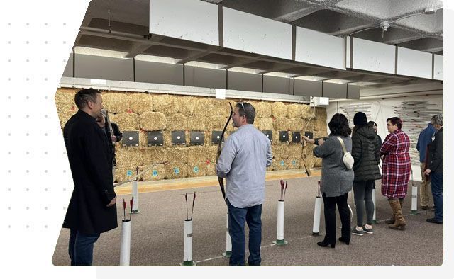 A group of people are standing in a room looking at targets.