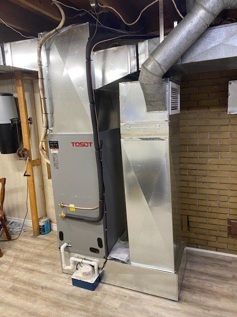 Un sous-sol avec une fournaise et un climatiseur.