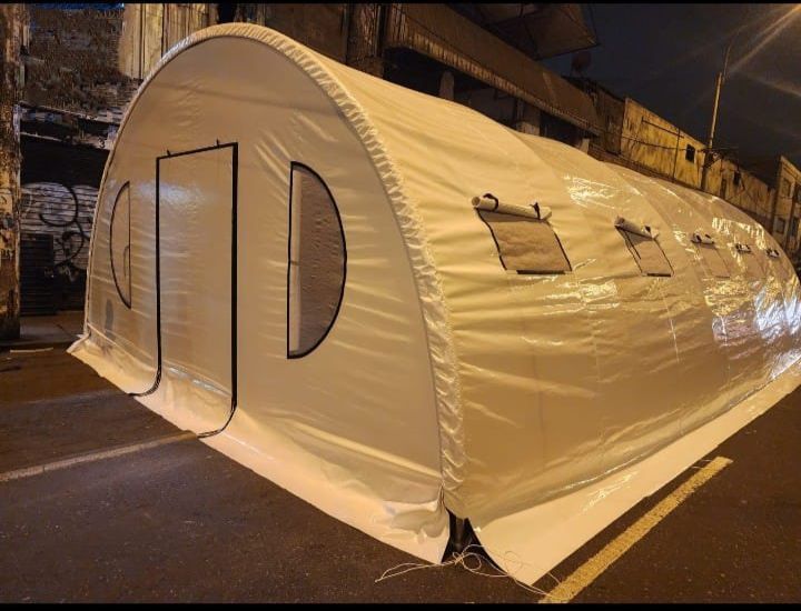 Una gran carpa blanca está al costado del camino.