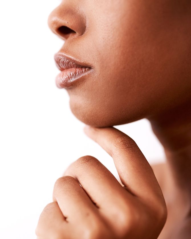 closeup of woman touching chin