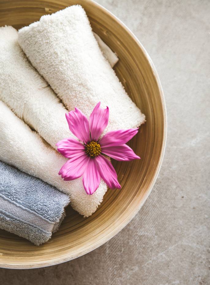 spa towels in a bowl with pink flower