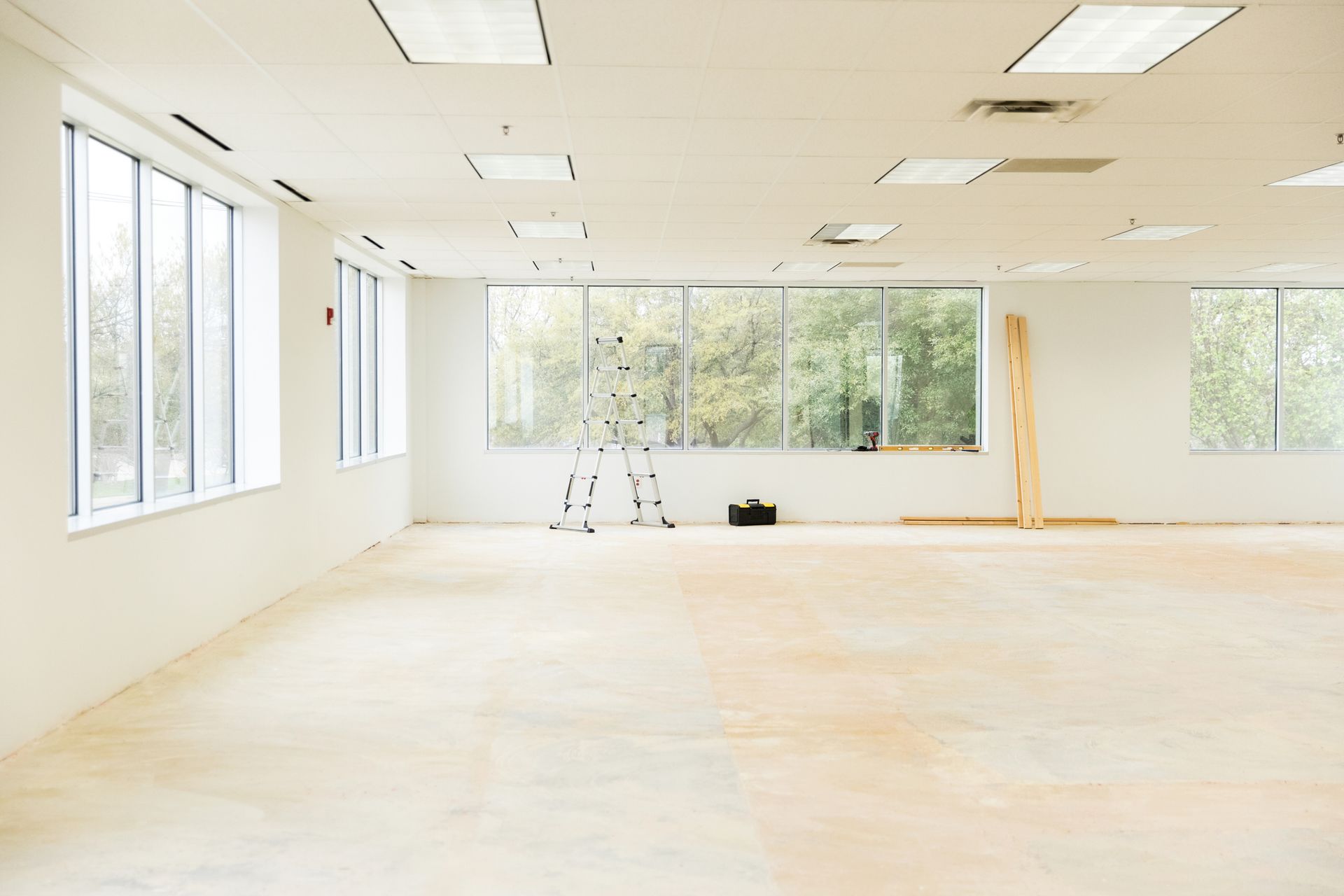 An empty room with a lot of windows and a wooden floor.