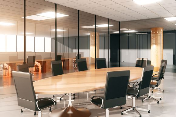 A conference room with a long wooden table and chairs.