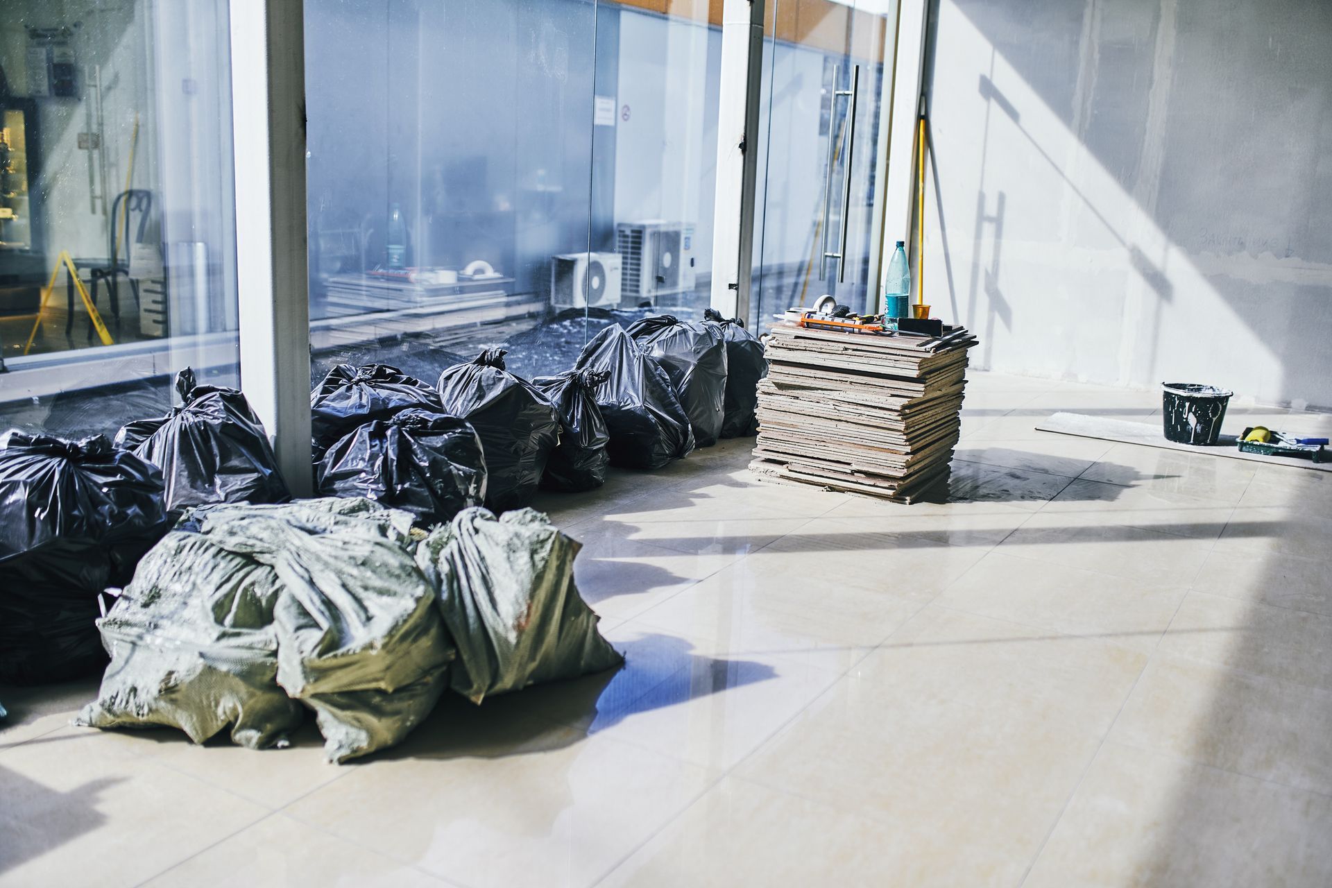 A room with a lot of trash bags on the floor.