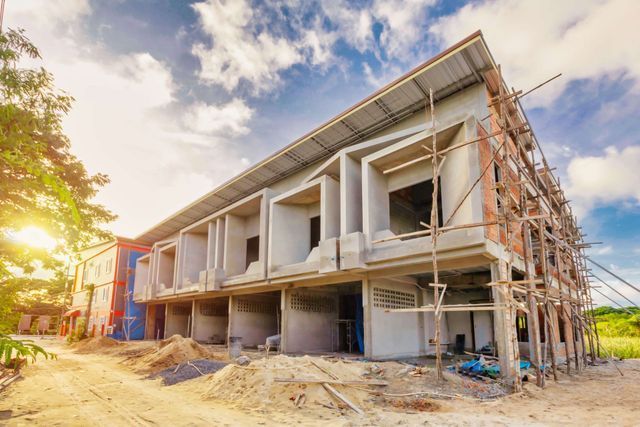 A large building is being built in the middle of a field.