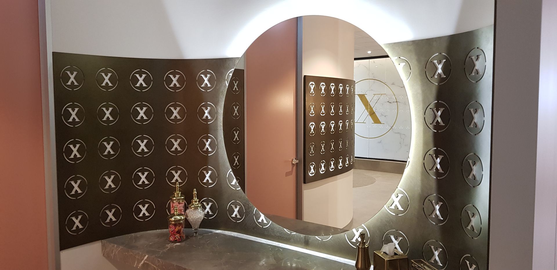 A round mirror with a light on it is in a room.