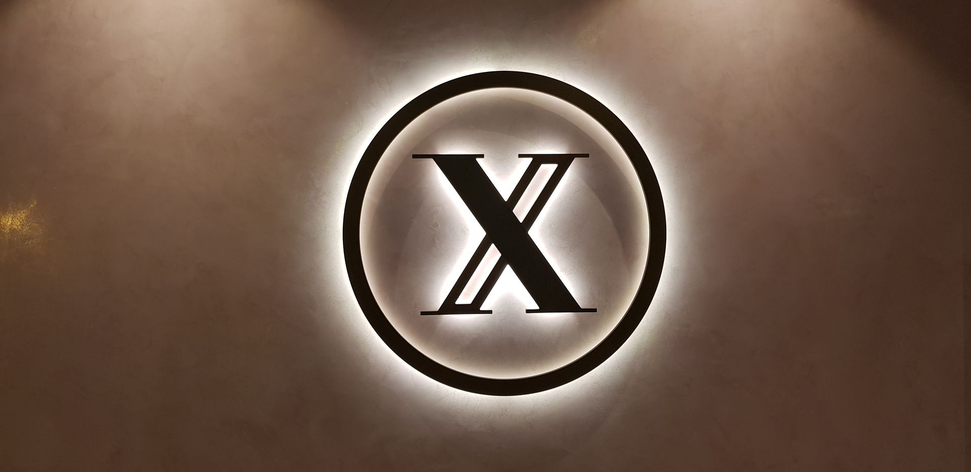 The letter x is in a circle on a brown background