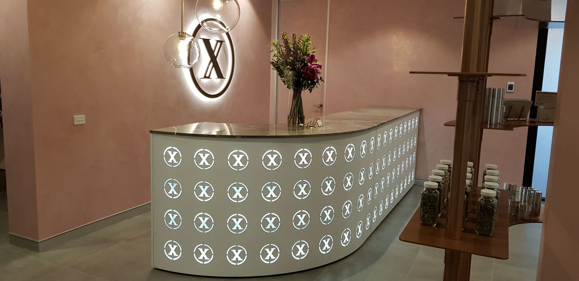 A reception desk with a vase of flowers on it in a room.