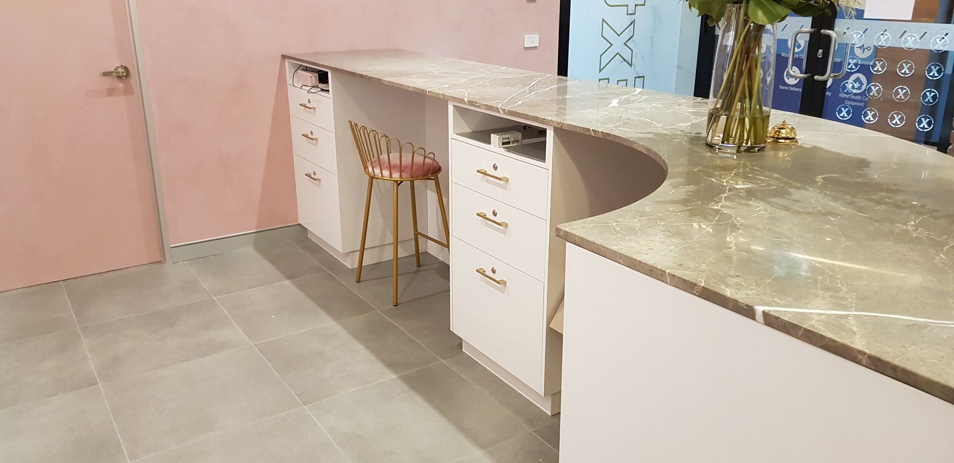 Cabinets with gold handles sitting underneath reception desk