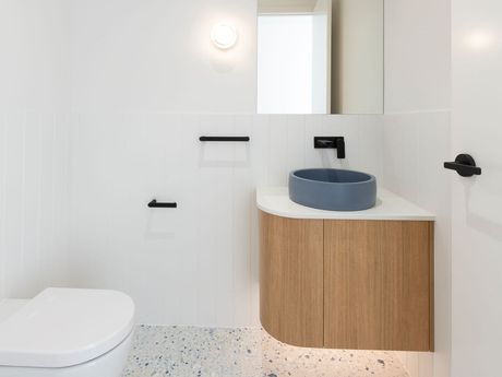 A bathroom with a toilet , sink and mirror.