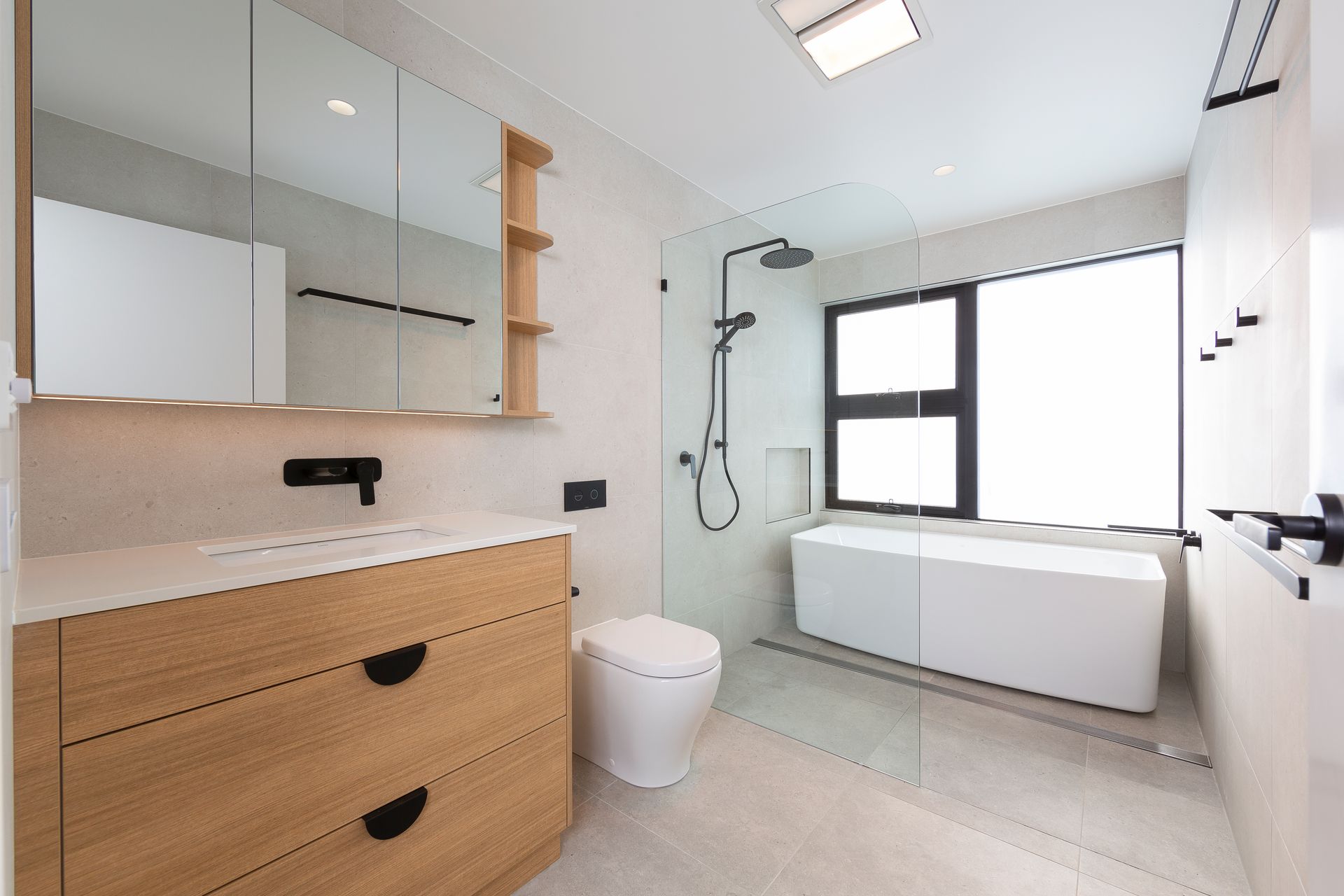 A bathroom with a toilet , sink , bathtub and shower.