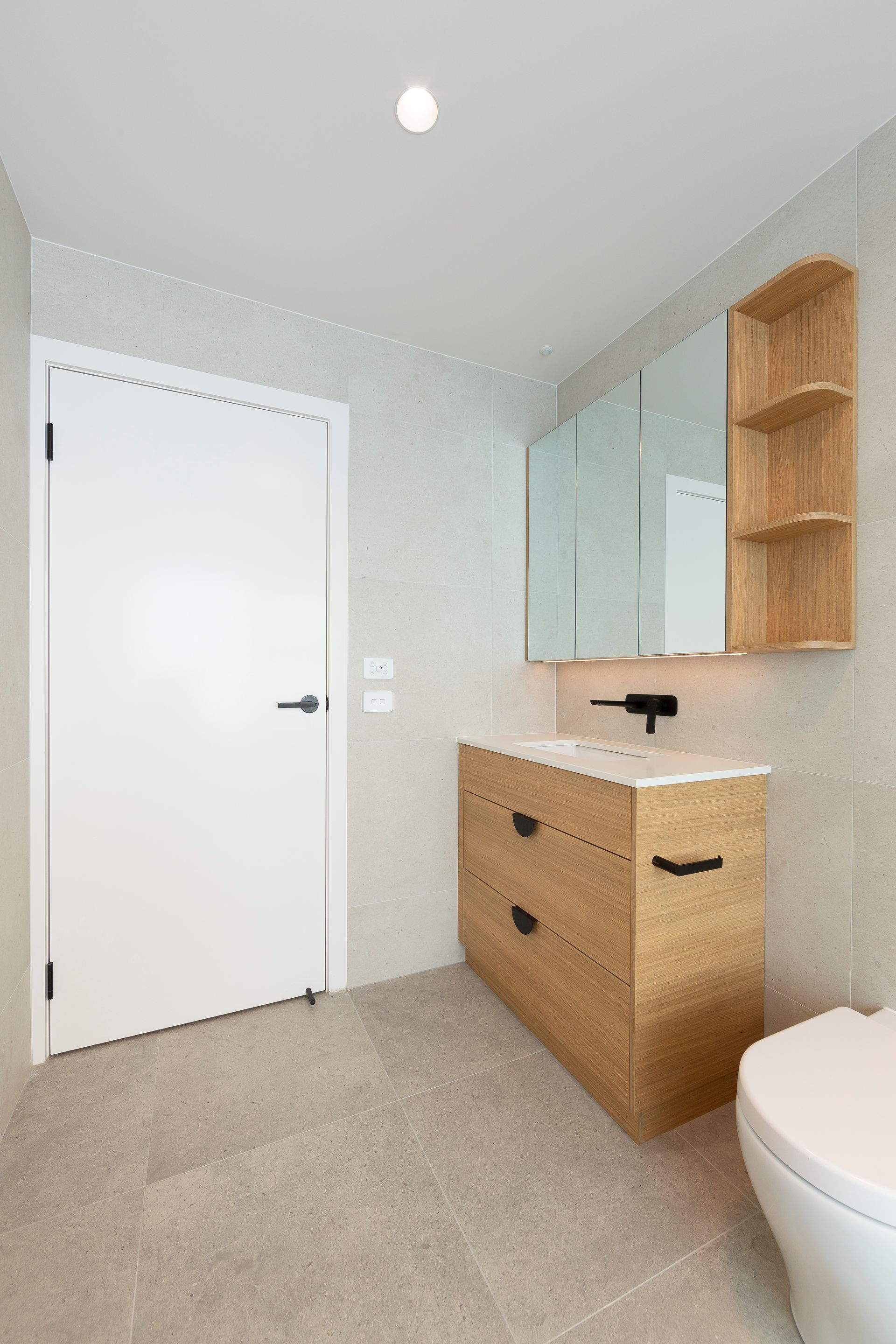 A bathroom with a sink , toilet and mirror.