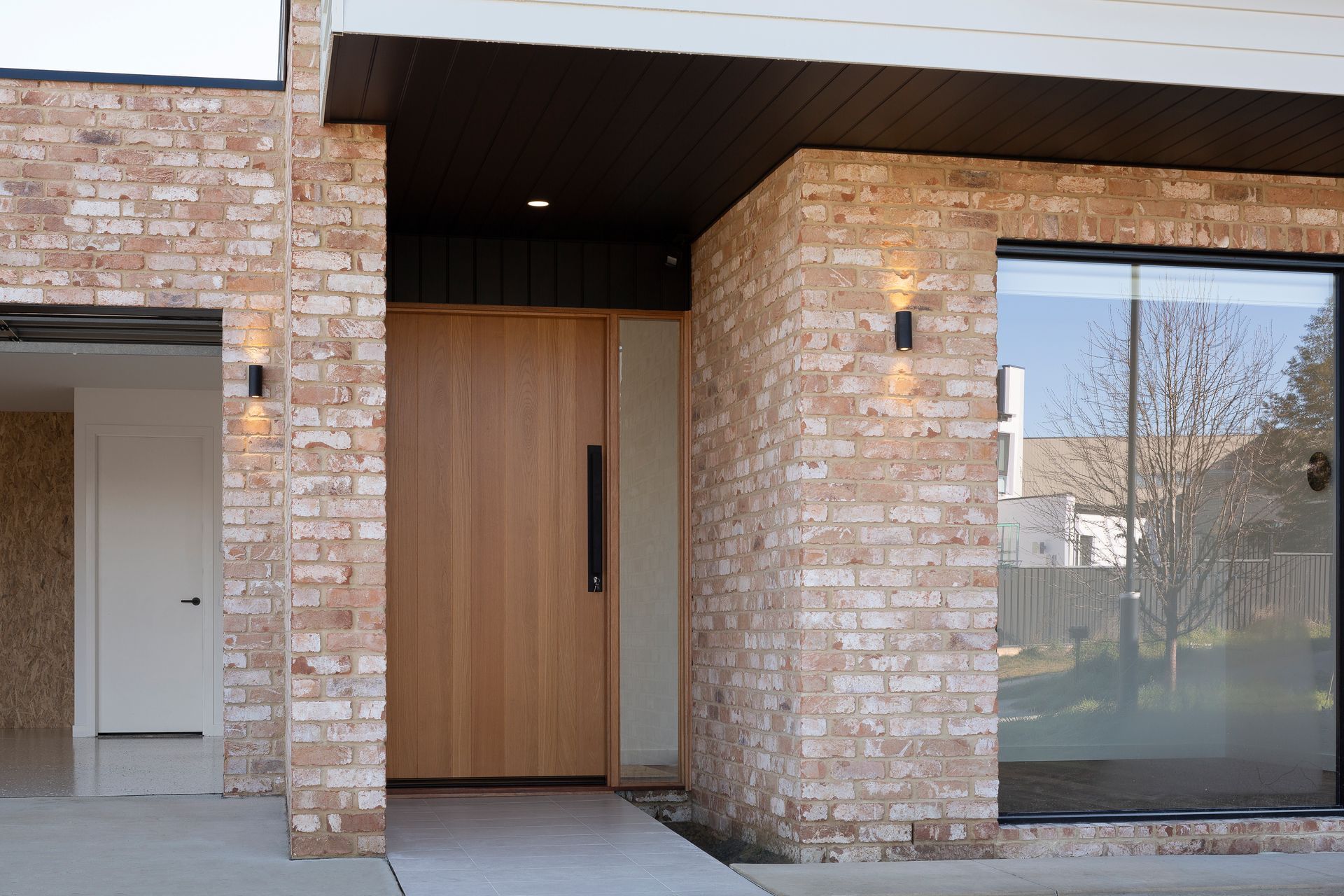 A brick building with a wooden door and sliding glass doors.