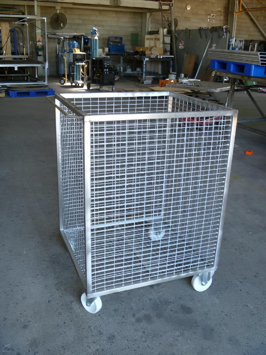 A Stainless Steel Cage With Wheels Sits In A Warehouse — Brian Martin's Sheet Metal In North Mackay, QLD