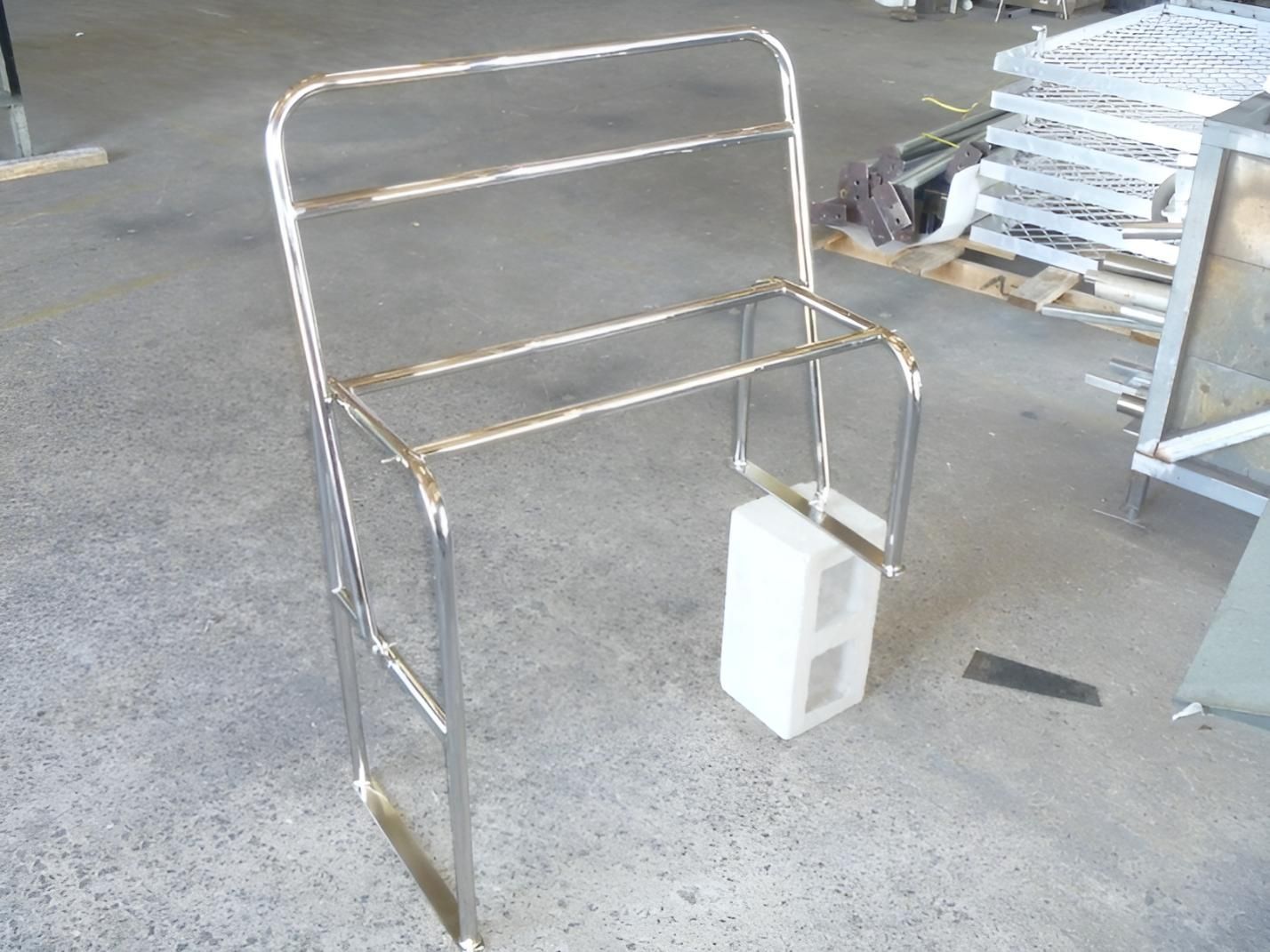 A Metal Chair Is Sitting On A Concrete Floor In A Warehouse — Brian Martin's Sheet Metal In North Mackay, QLD