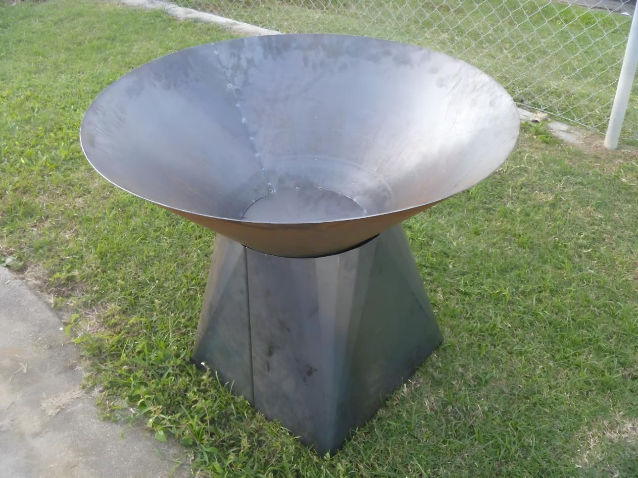 A Metal Bowl Is Sitting In The Grass Next To A Fence — Brian Martin's Sheet Metal In North Mackay, QLD