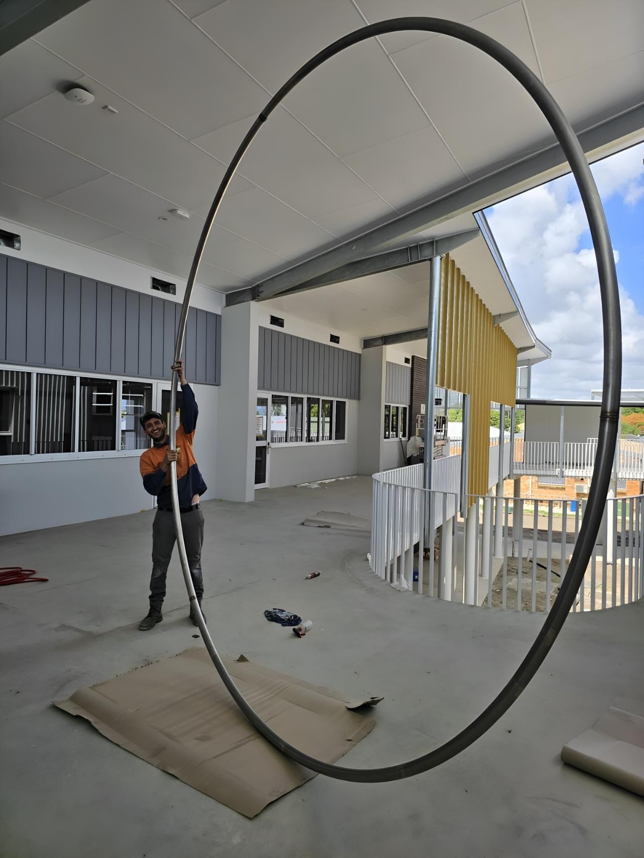 A Man Is Standing Next To A Large Metal Ring — Brian Martin's Sheet Metal In North Mackay, QLD
