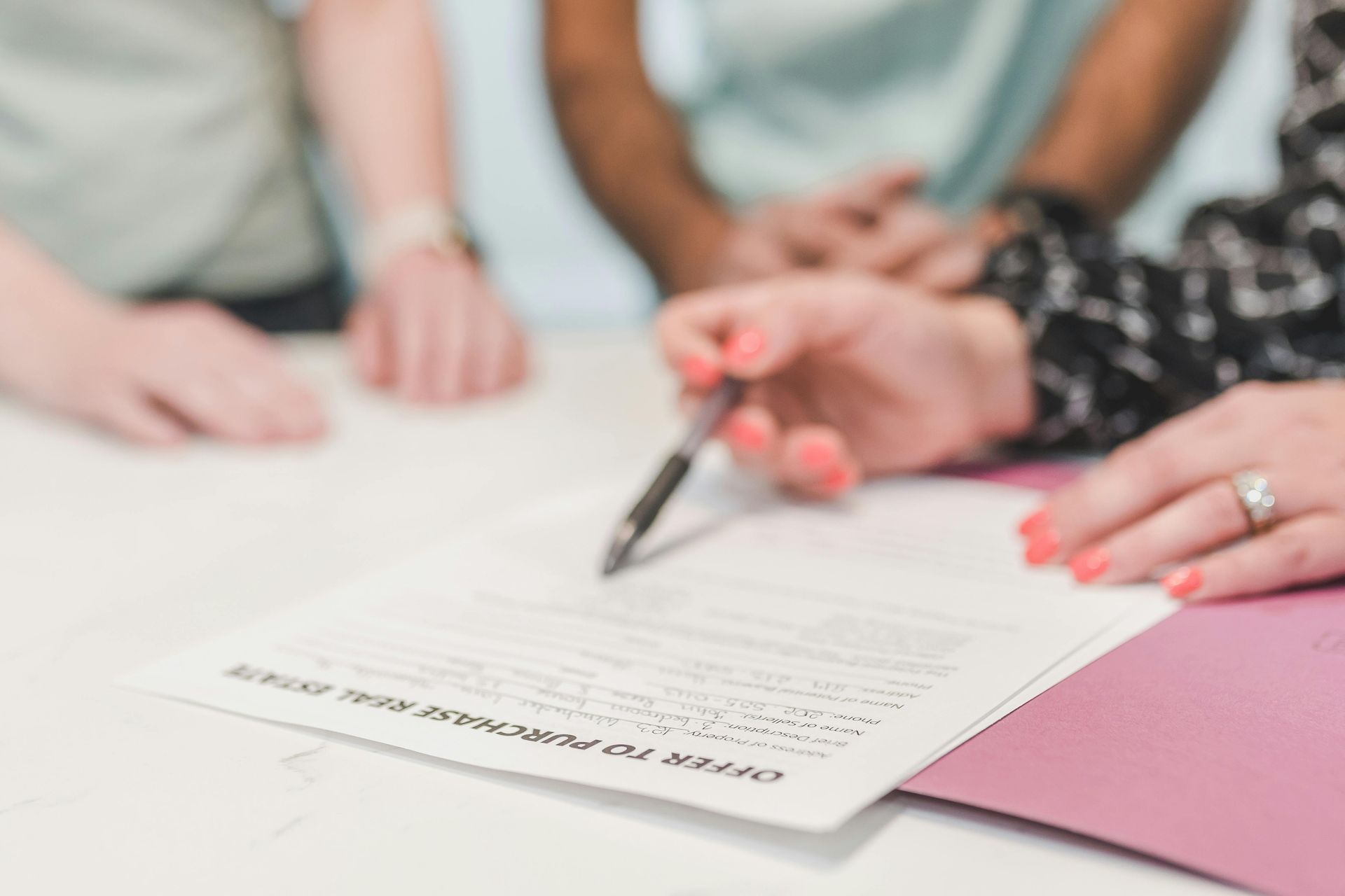 A group of people are sitting around a table signing a document.