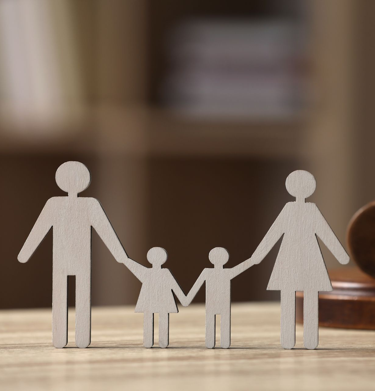 Cardboard cutout of a family: two parents holding hands with two children.