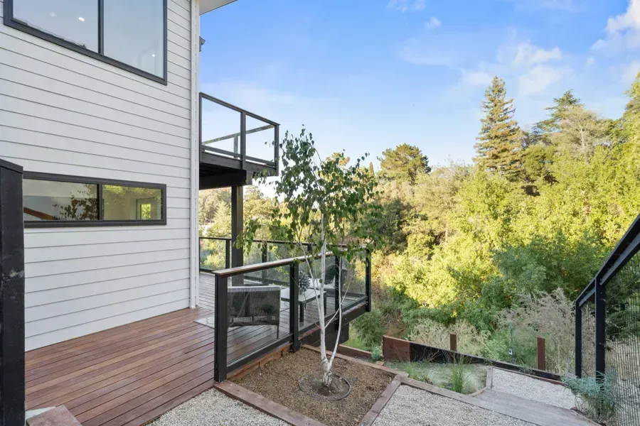 Exterior of modern home with deck and forest view.