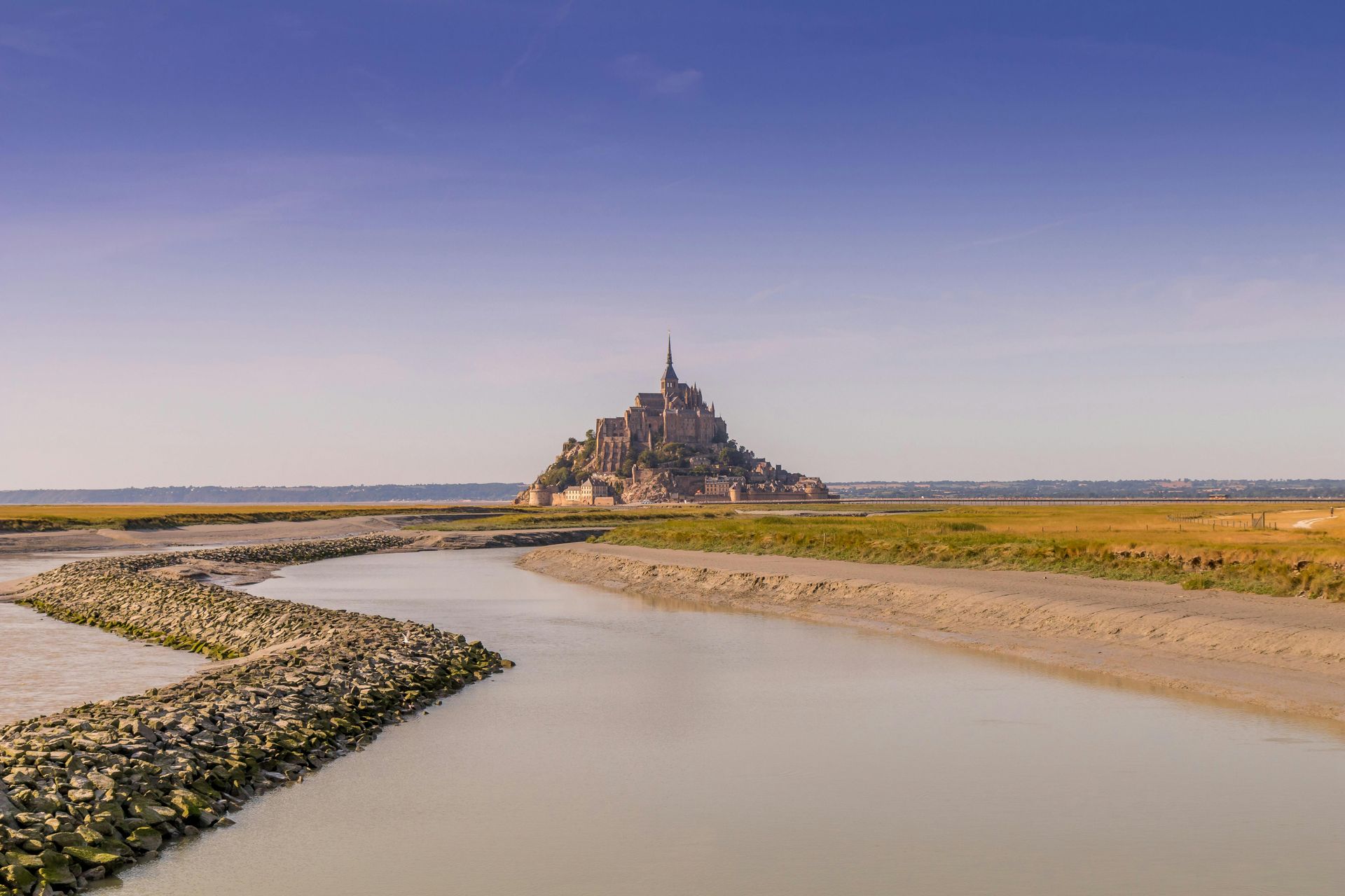 Aerial view of Mont Saint Michel, the famous medieval island and abbey in Normandy, France, surrounded by tidal waters.
