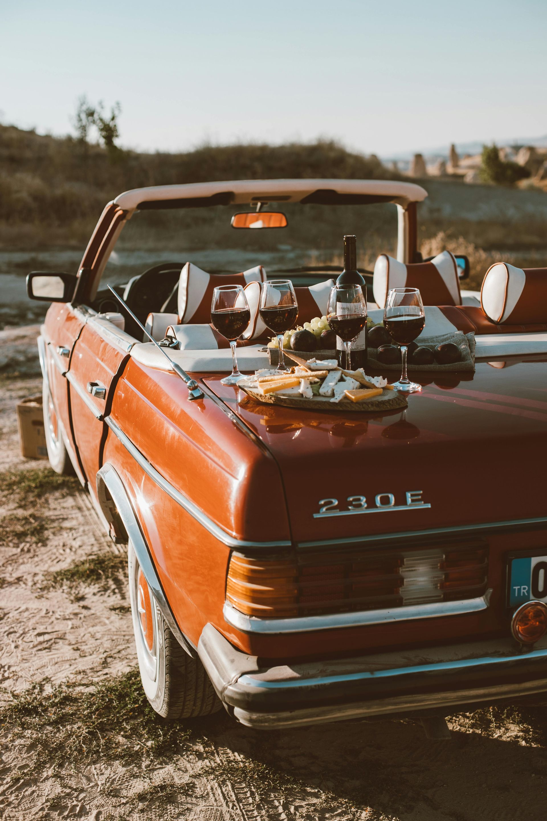 A scenic Bordeaux wine picnic setup on a vintage car, showcasing France’s wine culture.